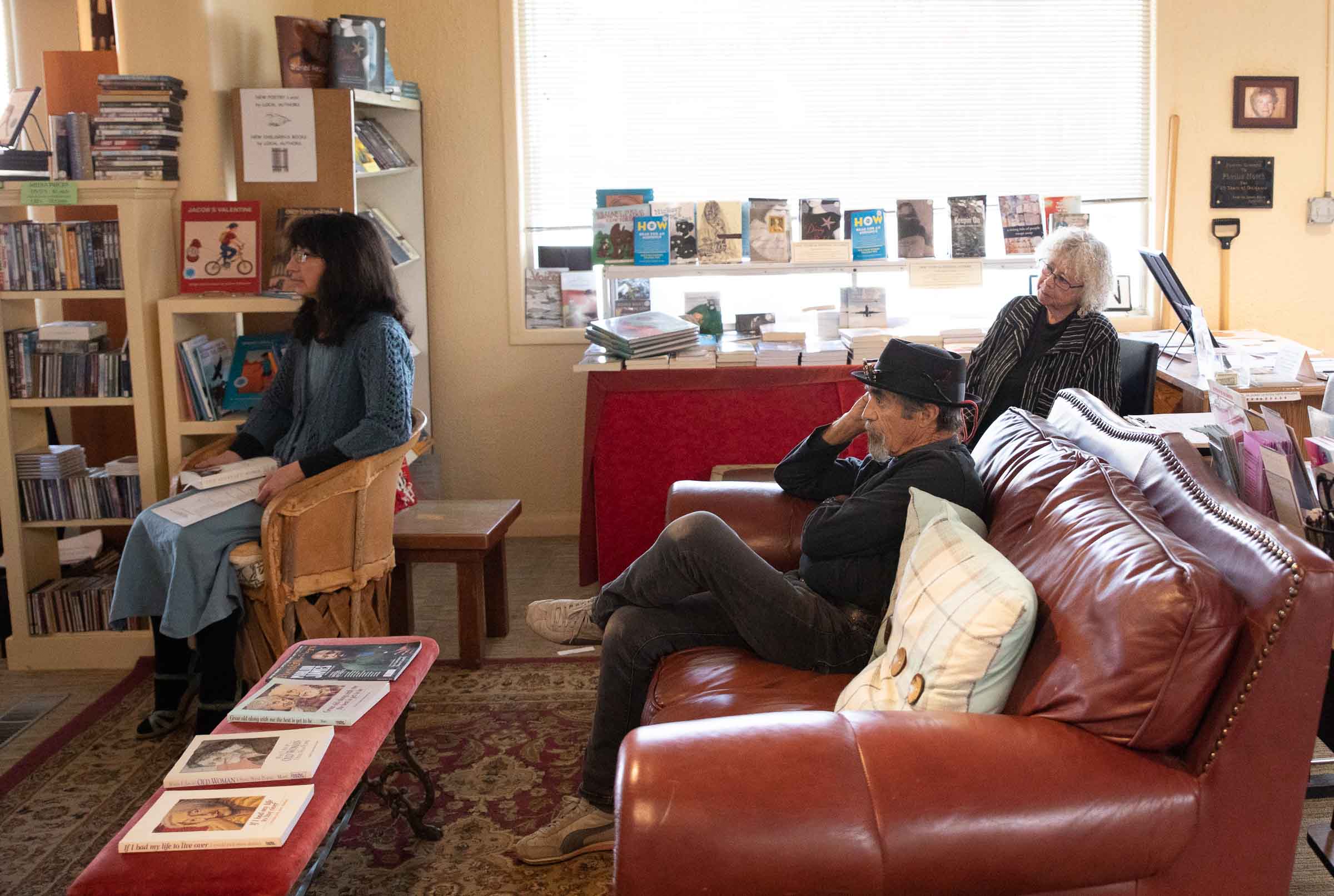 Three people listening to a speaker at SOMOS Boostore in Taos, New Mexico