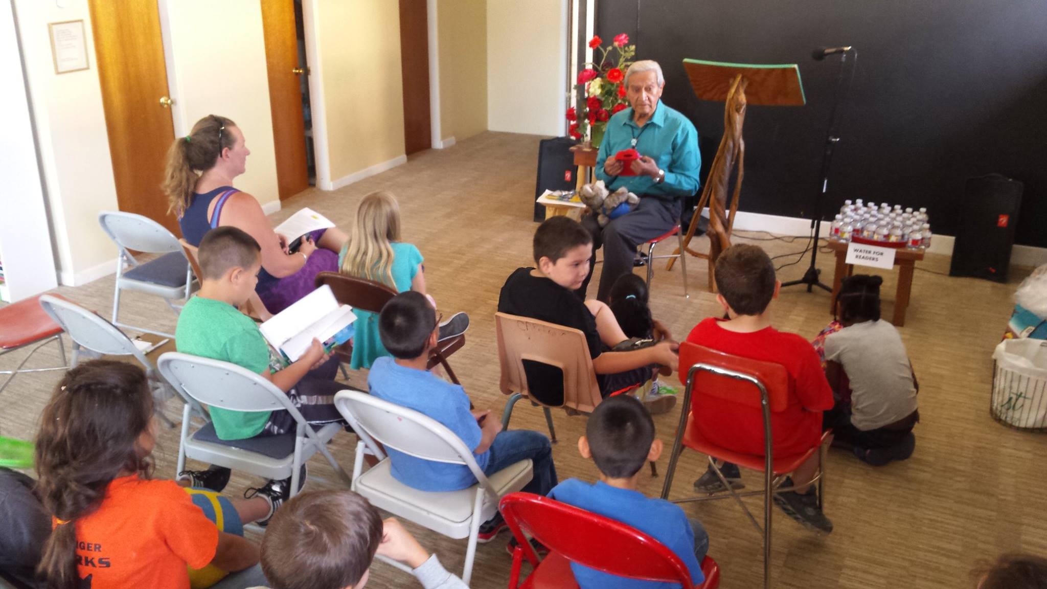 Four people sitting together talking and writing as part of the youth writers program at SOMOS.