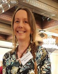 A woman holding an open book. SOMOS in Taos, New Mexico.
